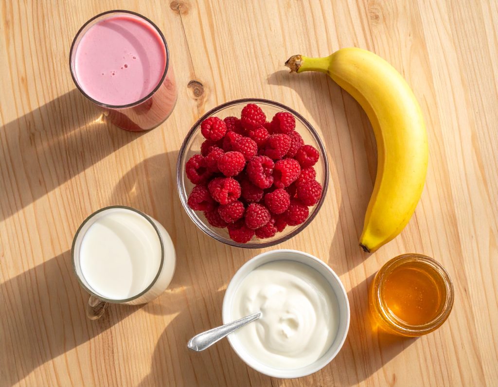 Zutaten für Cranberry-Smoothie mit Banane, Himbeeren, Joghurt und Cranberrysaft